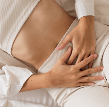 Woman resting hands on abdomen, symbolizing fertility awareness and care