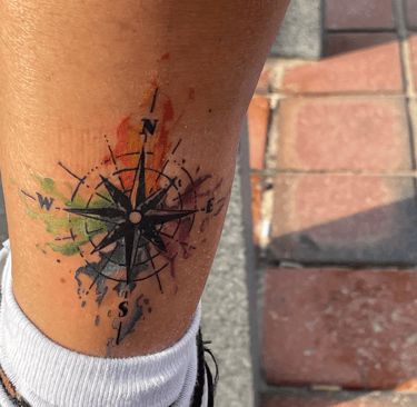 a picture of watercolor compass tattoo from a customer