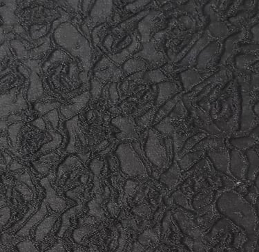 a close-up of a jacquard fabric with black three dimensional  floral patten