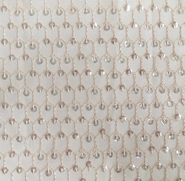 a close up of a white and silver colored beaded fabric with a chain link