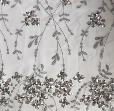 a fabric with silver sequinne and silver beads