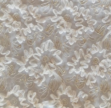 a white fabric with a gold threadwork and beads