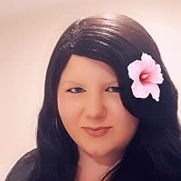 A young woman with a round face and a pink flower in her long black hair
