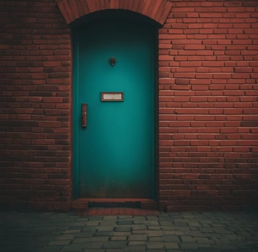A bright green door set in a wall of red brick