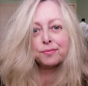 Image of a middle-aged woman with long blonde hair, big green eyes, and a nose ring