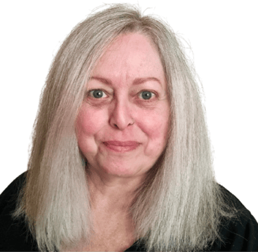 A middle aged white woman with long blonde hair, geen eyes, and wearing a black top