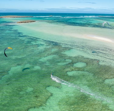 Spot de kitesurf de la baie de Sakalava à Madagascar avec plusieurs ailes en navigation, eau turquoi