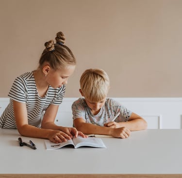 A little girl helping a boy study 