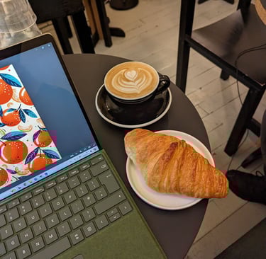 a laptop computer sitting on a table with a cup of coffee