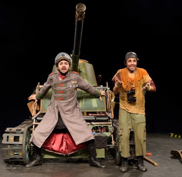two men in military uniforms standing next to a tank