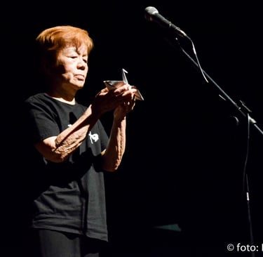 a woman in a black shirt is holding a cell phone