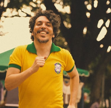 Smiling man running outdoors wearing a vintage yellow and green Brazil soccer jersey.