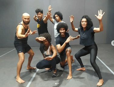 a group of people standing around a man in a black shirt