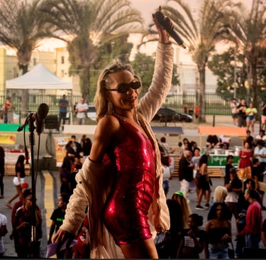 a woman in a red dress and sunglasses on a stage