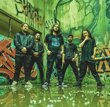 Heavy metal band posing in an abandoned building with green and orange graffiti walls.