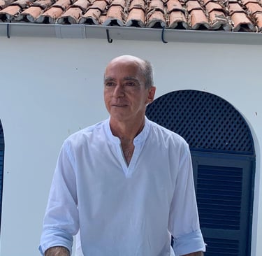 a man in a white shirt and jeans standing in front of a building