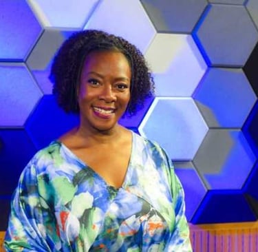a woman in a blue dress standing in front of a wall with hexagon