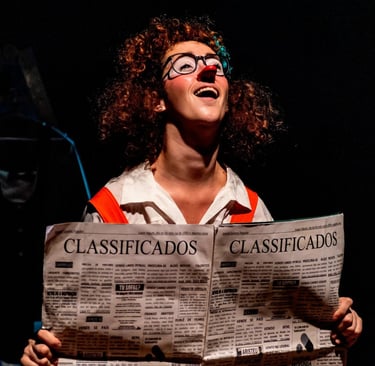 a woman in glasses and a red shirt is holding a newspaper
