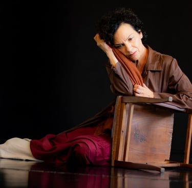 a woman sitting on a chair with a brown scarf
