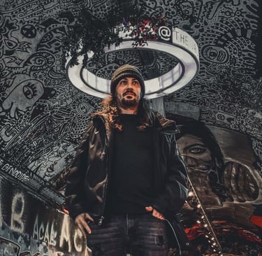 a man with long hair and a beard wearing a black jacket