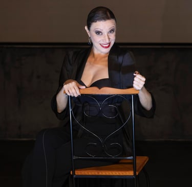 a woman in a black dress sitting on a chair