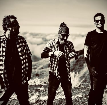 three men standing on a mountain top