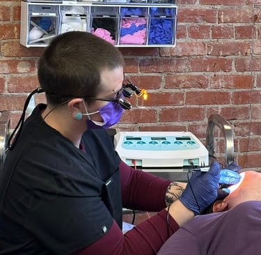 Sam with professional equipment on, treating a client with needle epilation