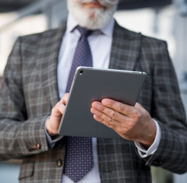 Alt txt: Profissional em ambiente corporativo utilizando tablet para empresa, com foco em mobilidade