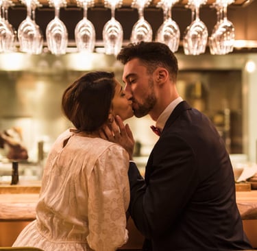 Sugar mommy and her sugar baby sharing a tender kiss in an upscale bar.