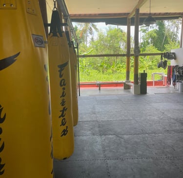 Salle dâentraĂźnement ouverte sur les riziĂšres Ă Ubud, avec tatami et sac de frappe, atmosphĂšre paisi