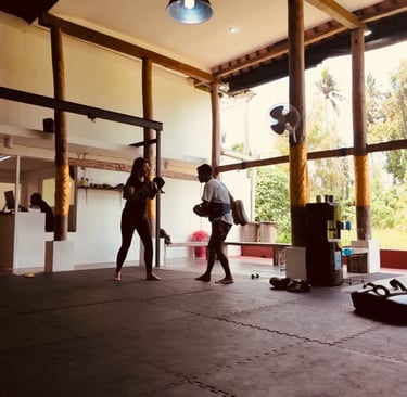 Entraînement de Muay Thaï à Ubud, Bali, dans une salle ouverte avec sac de frappe et tatami.