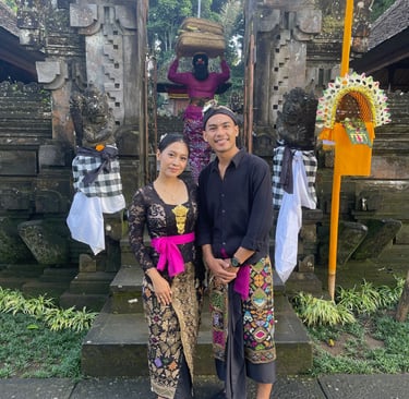Couple balinais en tenue traditionnelle devant un temple lors des célébrations.
