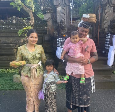 Famille balinaise en tenue traditionnelle devant un temple lors des célébrations.