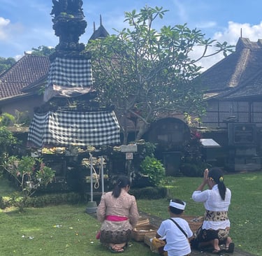Groupe de personnes priant devant un temple balinais lors des cérémonies.