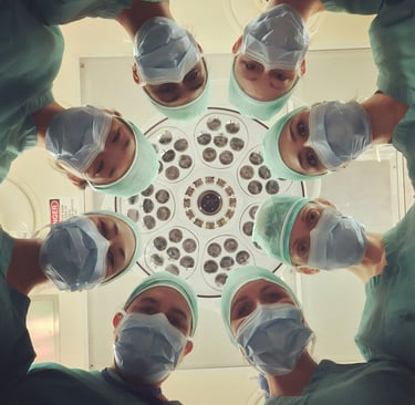 a group of surgeons in scrubies standing in a circle
