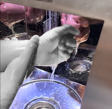a person is washing their hands in a sink