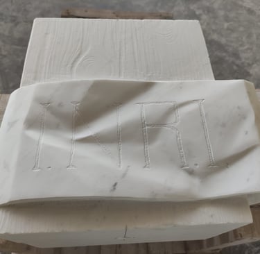 Hand-carved white marble sculpture featuring the INRI inscription with realistic fabric folds.