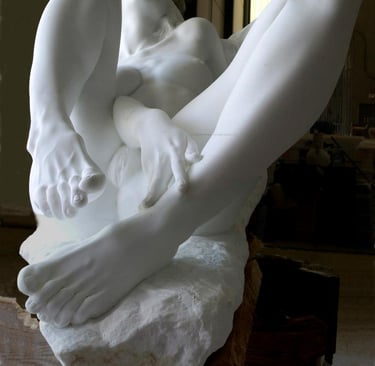Contemporary white marble sculpture of a reclining female figure with detailed hands and feet.