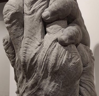 A detailed stone sculpture of two embracing hands on display at the MUREC Museum of Realism art