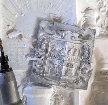 Hand-carved stone family crest plaque being detailed with rotary power engraving tools.