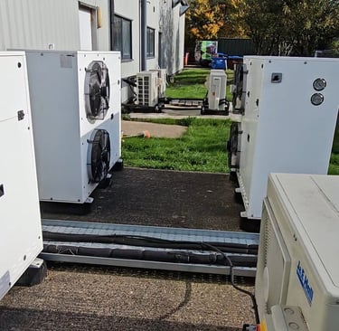 a group of refrigerators and spilit cooling units in a yard