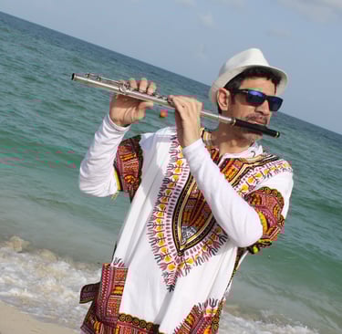 Maestro Bobby Ramirez wearing a Djembe shirt playing flute in Maimi Beach