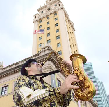 Bobby Ramirez playing the saxophone in front of Freedom Tower Miami