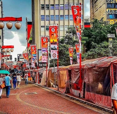 Rua Liberdade em São Paulo, com lanternas japonesas, bandeiras e uma feirinha.