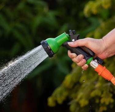 Arrosage précis au pistolet réglable sur un balcon, geste simple pour économiser l’eau