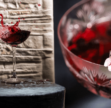 Calice di vino rosso in splash creativo fotografato da Gaudife a Bologna – still life emozionale per brand artigianali.