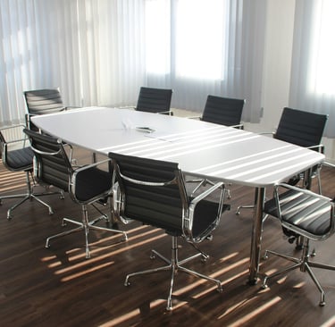 Modern meeting room with white conference table and black chairs