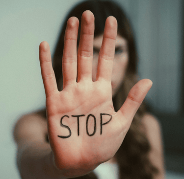a woman holding a stop sign with the word stop written on it