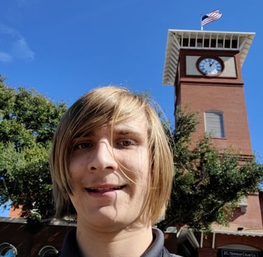 The Owner of the lutz clock company in frount of a clock tower