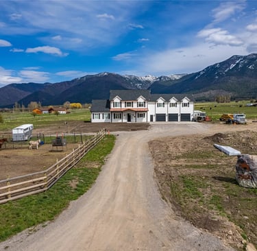 a dirt road with a horse and mountains in the background in Montana